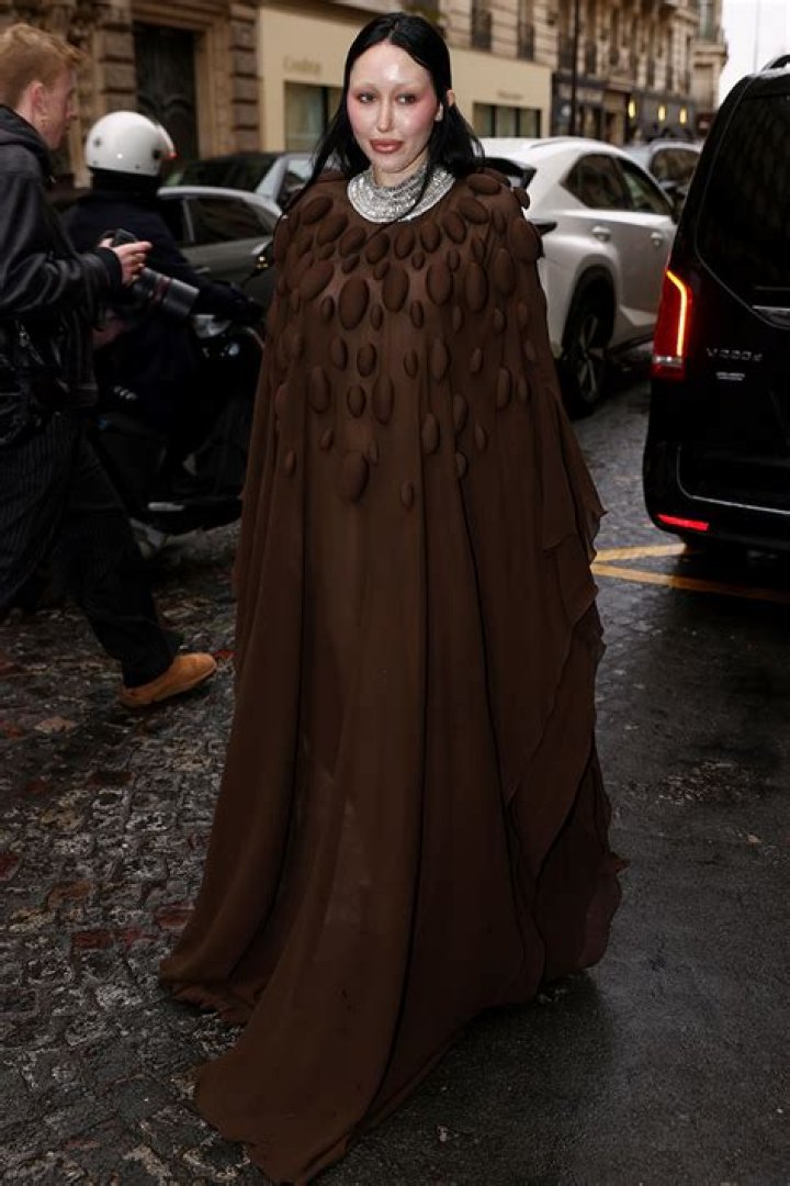 Noah Cyrus Makes Rare Public Appearance in Sheer Brown Cape Dress at Paris Fashion Week